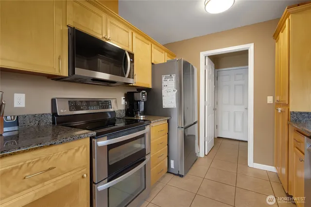 a kitchen with stainless steel appliances granite countertop a refrigerator and a stove top oven
