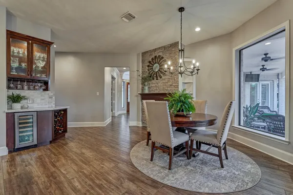 a dining room with furniture a chandelier and wooden floor