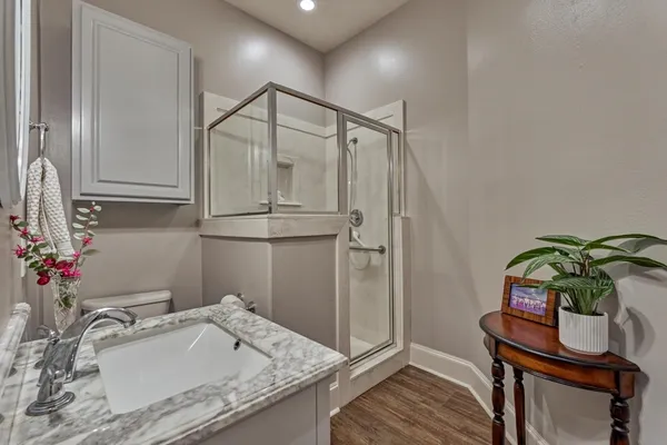 a bathroom with a granite countertop sink a mirror and shower