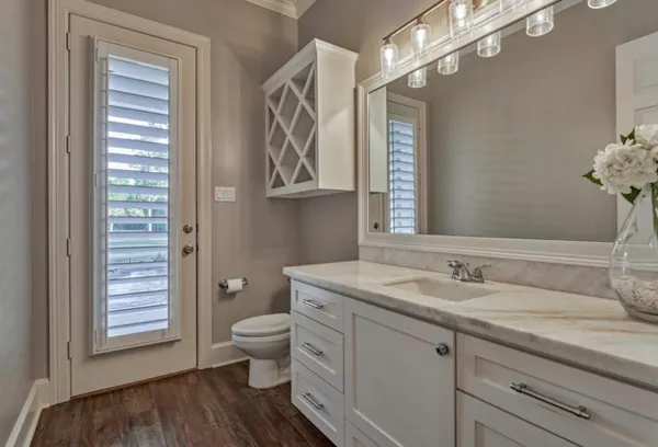 a spacious bathroom with a granite countertop sink a toilet and a mirror