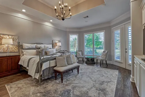 a spacious bedroom with a bed and a chandelier