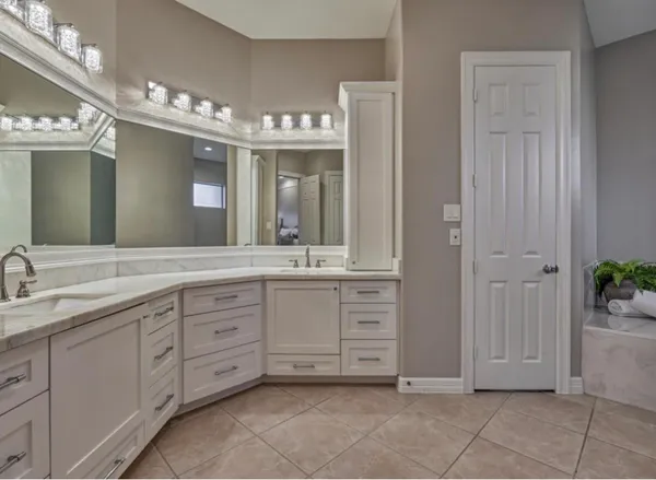 a spacious bathroom with a mirror and a sink