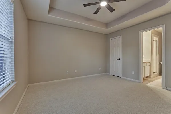 en empty room with windows and chandelier fan