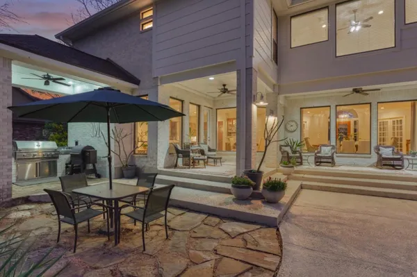 a dining area with furniture and table under an umbrella