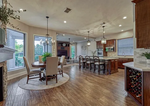 a dining room with furniture a chandelier and wooden floor
