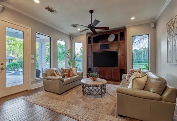 a living room with furniture a flat screen tv and a large window