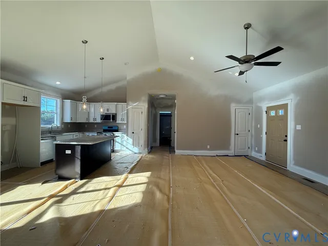 an empty room with windows and fan