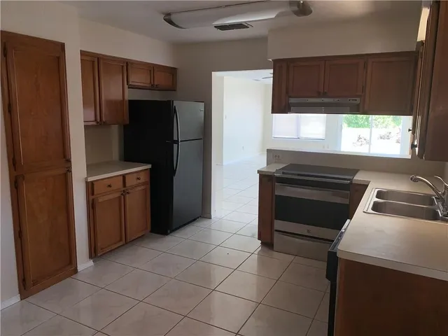 a kitchen with a refrigerator sink and cabinets