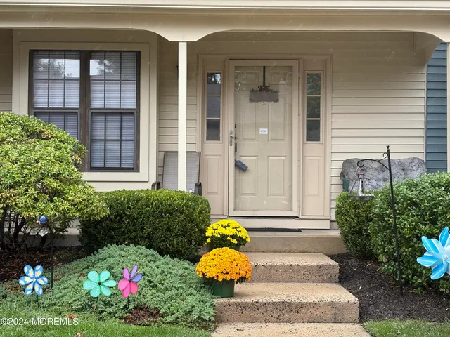 a front view of a house with large windows and flowers