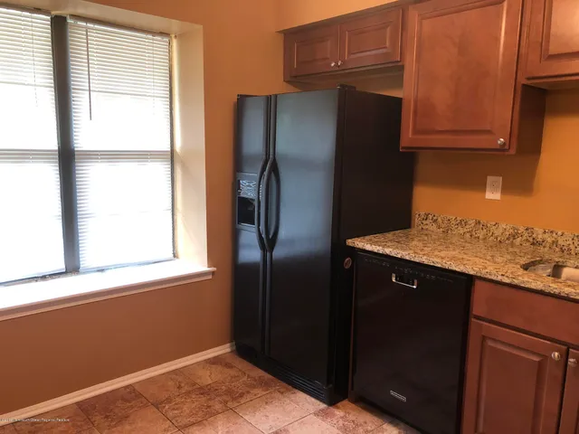 a kitchen with stainless steel appliances granite countertop a refrigerator and a sink
