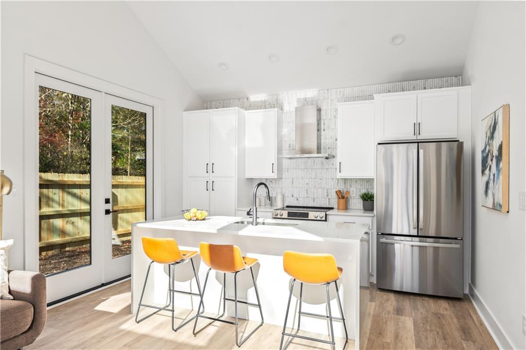 845 Ormewood Terrace Southeast, Unit C Atlanta, GA 30316 - Photo 17 of 37 a kitchen with stainless steel appliances granite countertop a refrigerator a stove a sink dishwasher and white cabinets with wooden floor