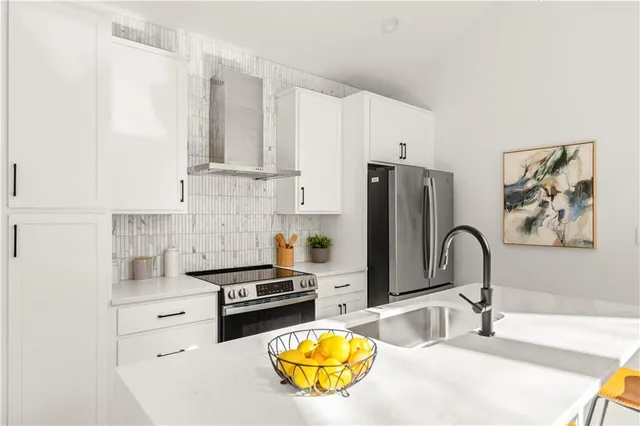 a kitchen with granite countertop a stove a sink and a refrigerator