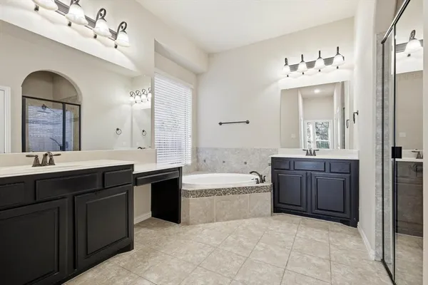 a spacious bathroom with a tub sink and mirror
