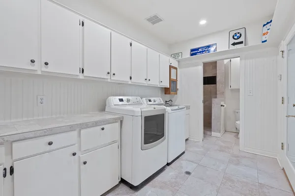 a utility room with cabinets washer and dryer