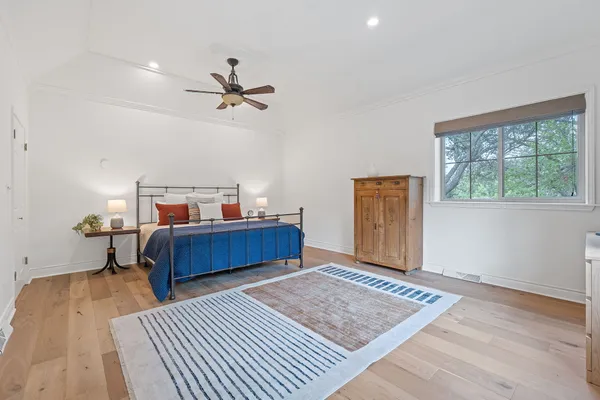 a bedroom with a bed and wooden floor