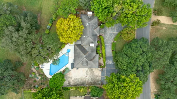 an aerial view of a house with large trees