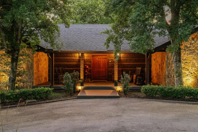 a view of a patio with couches table and chairs under an umbrella with wooden floor