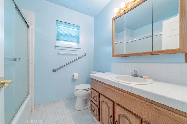 a bathroom with a sink a toilet and mirror