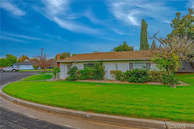 a view of a house with a yard and potted plants