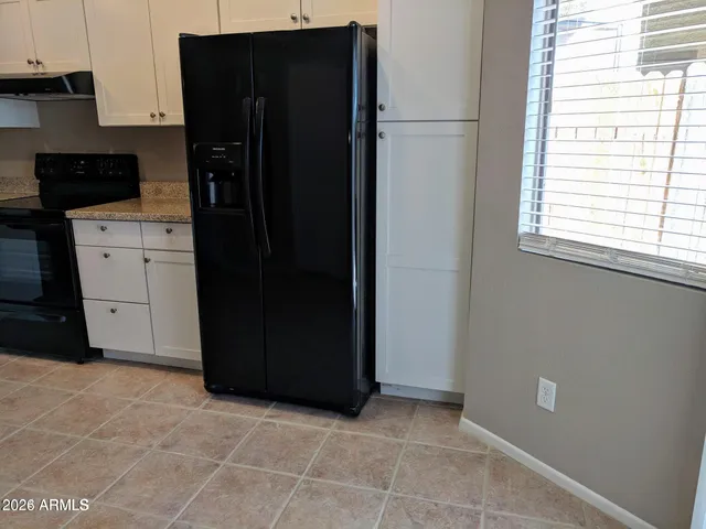 a kitchen with granite countertop a refrigerator and a stove