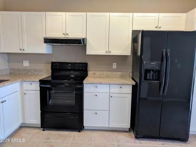 a kitchen with stainless steel appliances granite countertop a refrigerator and a stove