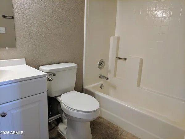 a white toilet sitting next to a bath tub