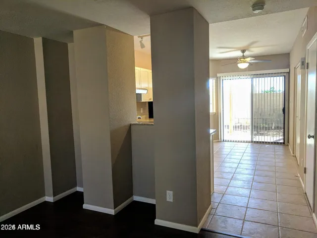 a view of a hallway with wooden floor and a bathroom