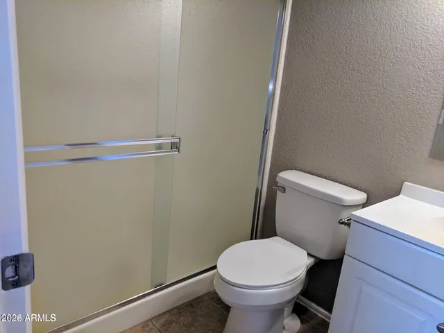 a white toilet sitting next to a shower
