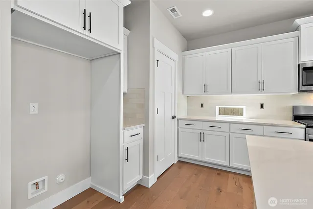 a kitchen with white cabinets and stainless steel appliances
