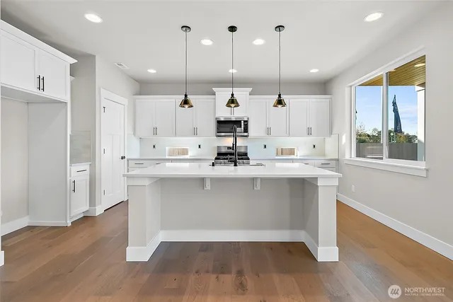 a kitchen with white cabinets and sink