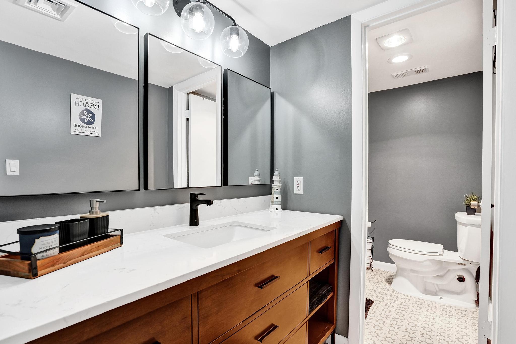 300 Ocean Trail Way, Unit 410 Jupiter, FL 33477 - Photo 37 of 58 a bathroom with a double vanity sink toilet and mirror