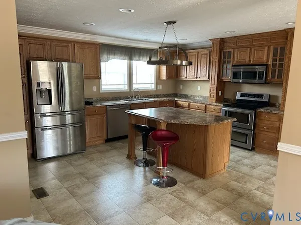 a kitchen with stainless steel appliances granite countertop a sink a stove and a refrigerator