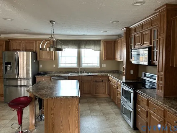 a kitchen with stainless steel appliances granite countertop a sink and a refrigerator