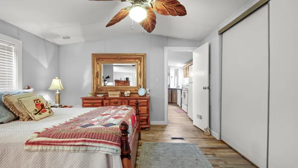 a bedroom with bed and wooden floor
