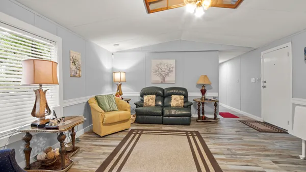 a living room with furniture a rug and white walls