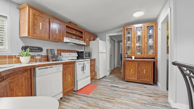 a kitchen with stainless steel appliances granite countertop a refrigerator and wooden cabinets