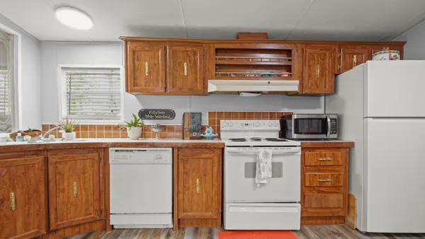a kitchen with stainless steel appliances granite countertop a refrigerator and a stove top oven
