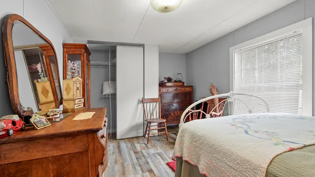 a bedroom with a bed and a large mirror on the dresser