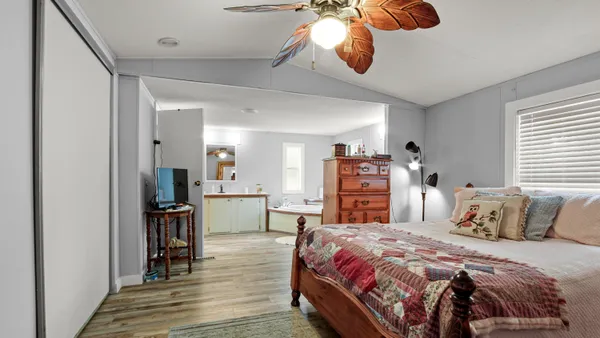 a bedroom with a bed and wooden floor