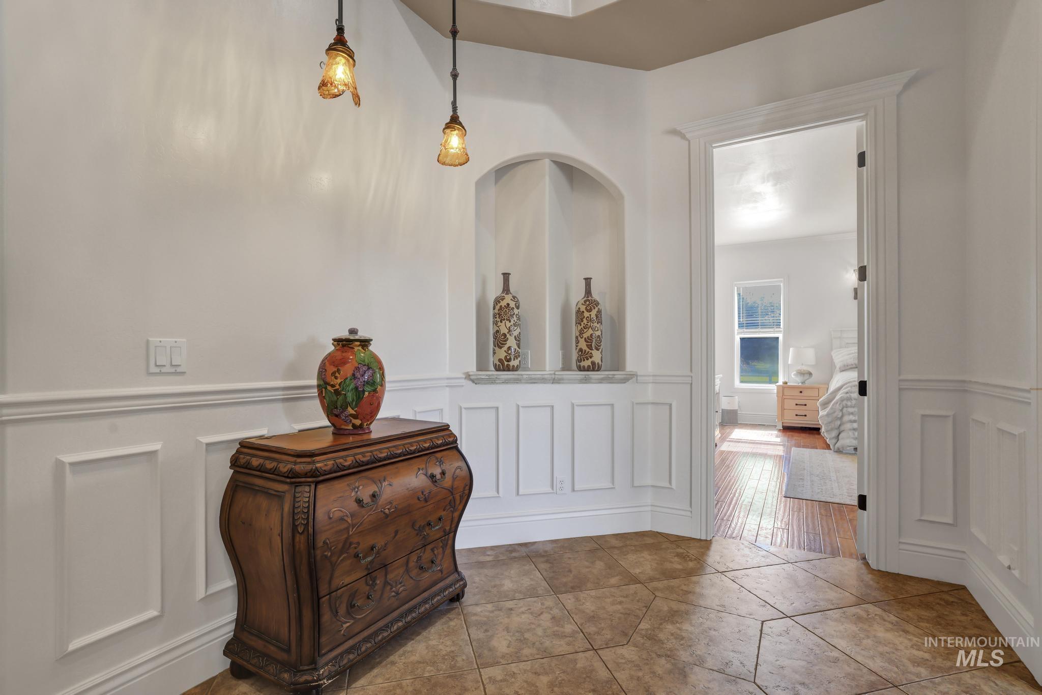 1301 Kanaka Rapids Road Buhl, ID 83316 - Photo 14 of 50 Hallway featuring wainscoting, a built-in arched niche with a stone surface, and hexagonal floor tiling