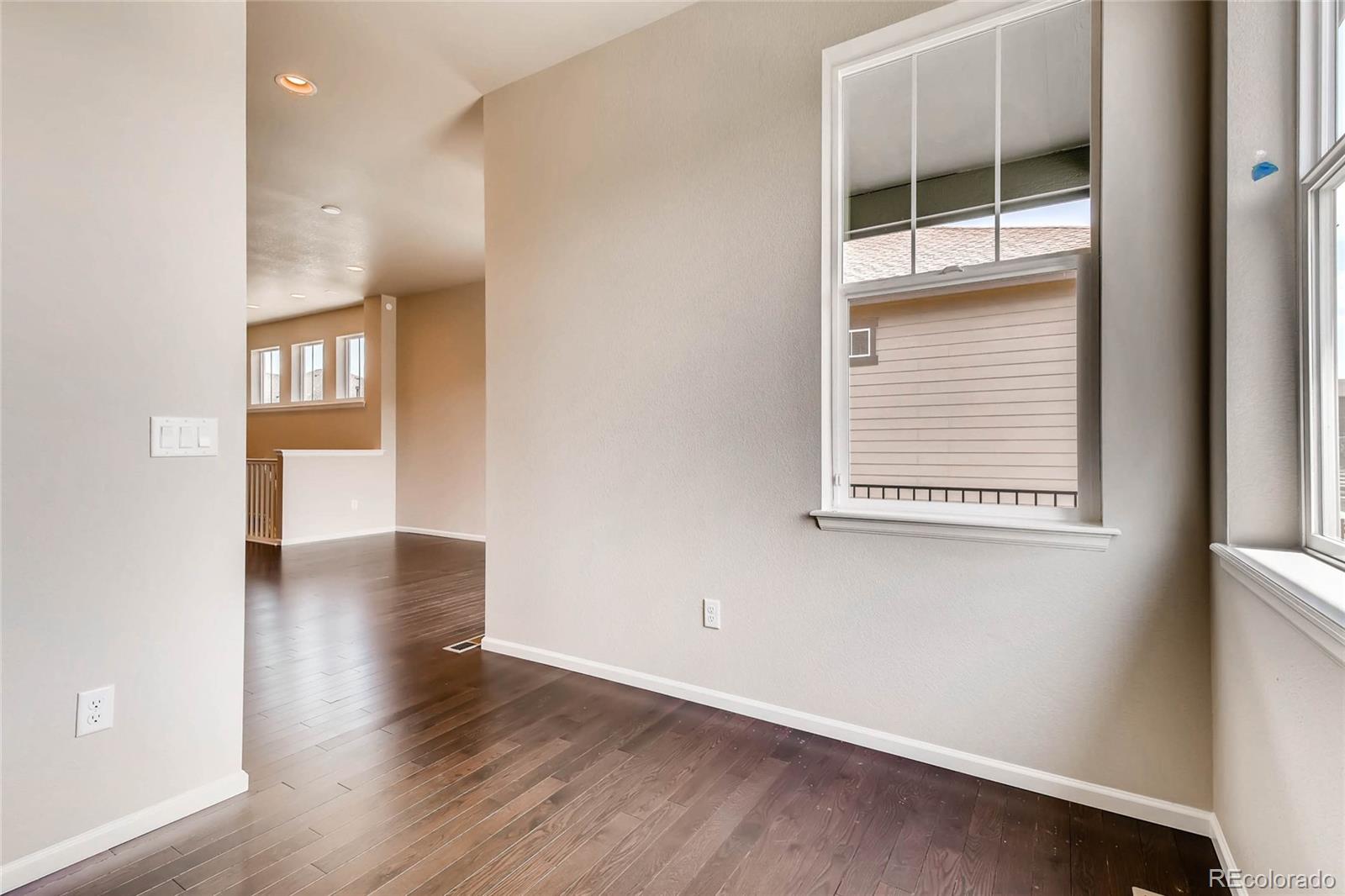 5052 West 109th Circle Westminster, CO 80031 - Photo 8 of 30 an empty room with wooden floor and windows