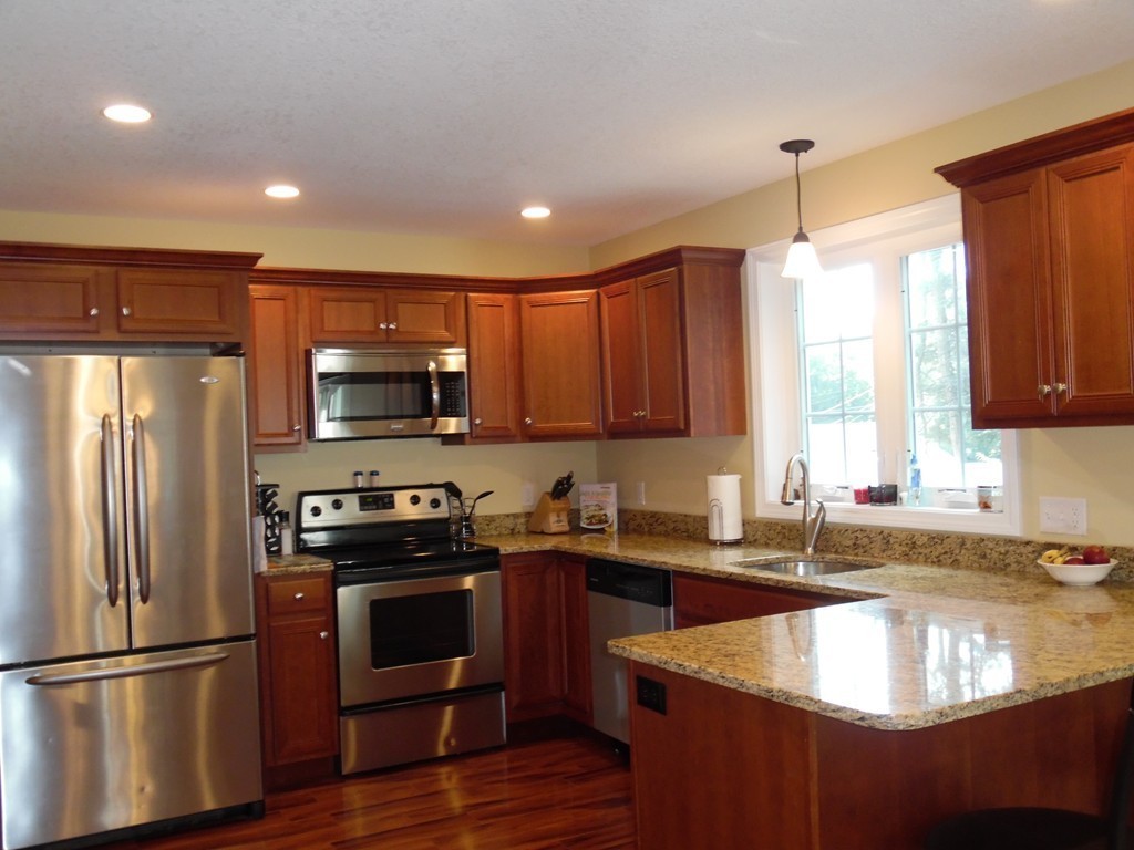 230 Russell Street Springfield, MA 01104 - Photo 3 of 18 a kitchen with stainless steel appliances granite countertop a sink a stove a refrigerator a center island and wooden cabinets