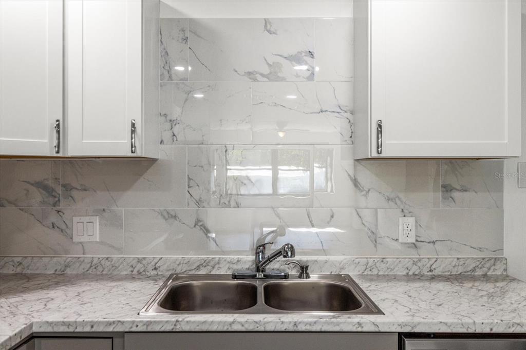 5700 South Calgary Terrace Inverness, FL 34452 - Photo 11 of 39 a kitchen with granite countertop a sink a window and cabinets