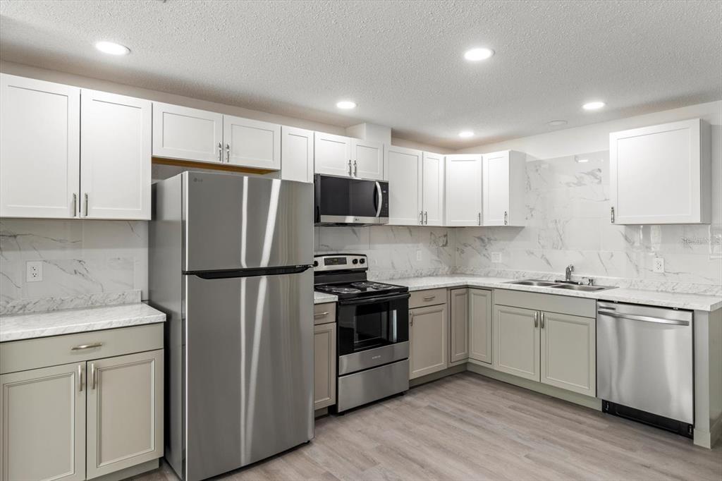 5700 South Calgary Terrace Inverness, FL 34452 - Photo 12 of 39 a kitchen with white cabinets and stainless steel appliances