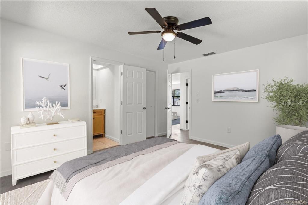 5700 South Calgary Terrace Inverness, FL 34452 - Photo 21 of 39 a bedroom with a large bed and a chandelier