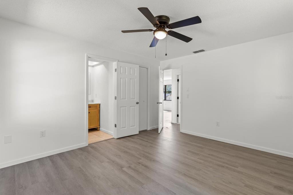 5700 South Calgary Terrace Inverness, FL 34452 - Photo 22 of 39 an empty room with wooden floor ceiling fan and windows