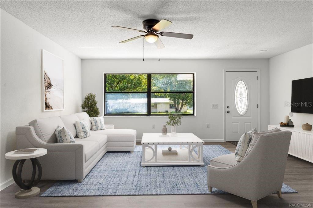 5700 South Calgary Terrace Inverness, FL 34452 - Photo 5 of 39 a living room with furniture a chandelier and a large window