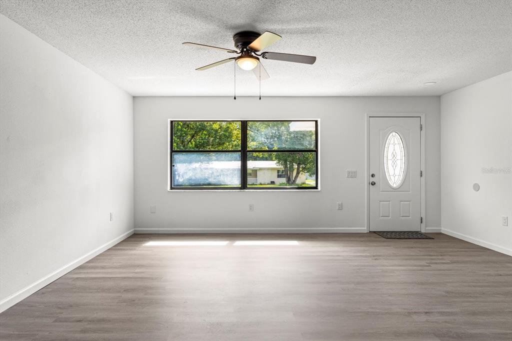 5700 South Calgary Terrace Inverness, FL 34452 - Photo 6 of 39 an empty room with wooden floor chandelier and windows