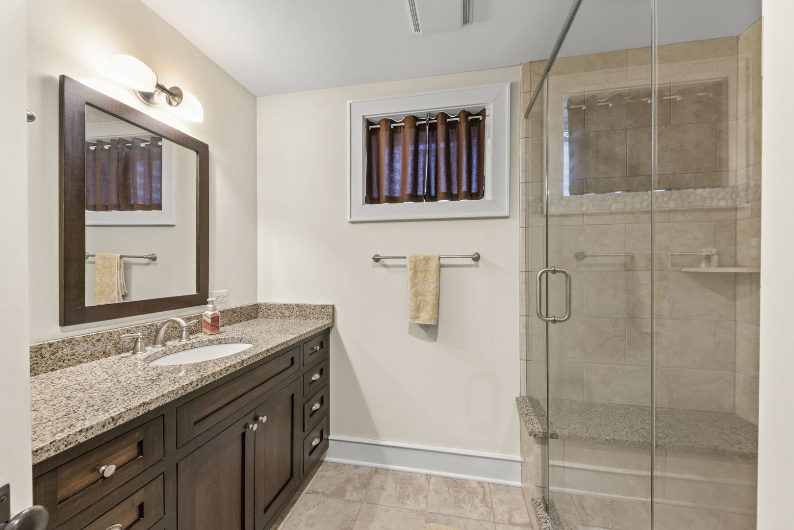 900 East Indiana Street Wheaton, IL 60187 - Photo 38 of 54 a bathroom with a granite countertop sink a mirror a vanity and shower