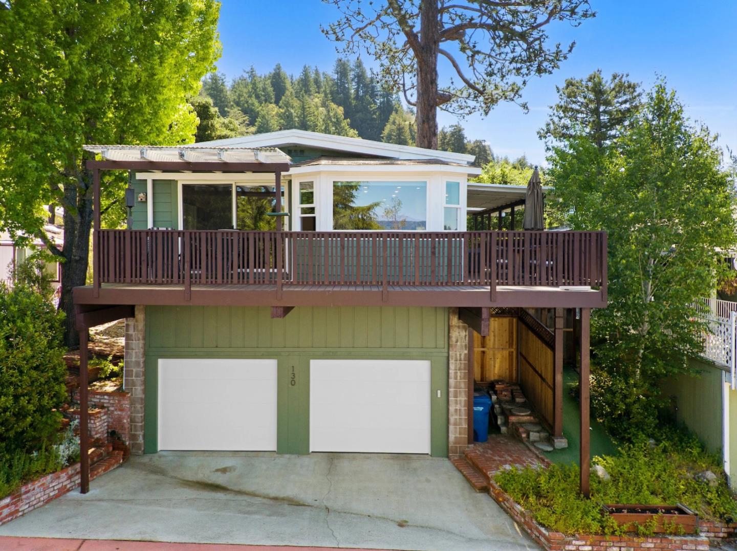 a view of a white house with large windows and a small yard